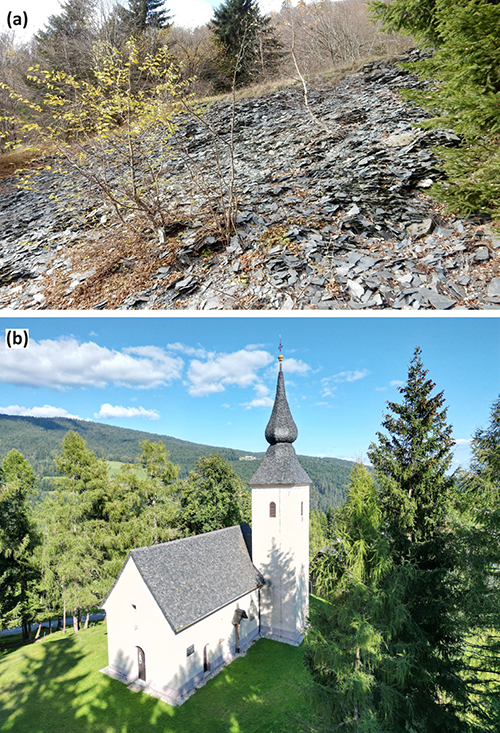 Un terreno rocoso con árboles dispersos en la parte superior y una iglesia blanca con techo gris y una torre con aguja rodeada de árboles verdes bajo un cielo azul con algunas nubes.

Descripción generada con IA