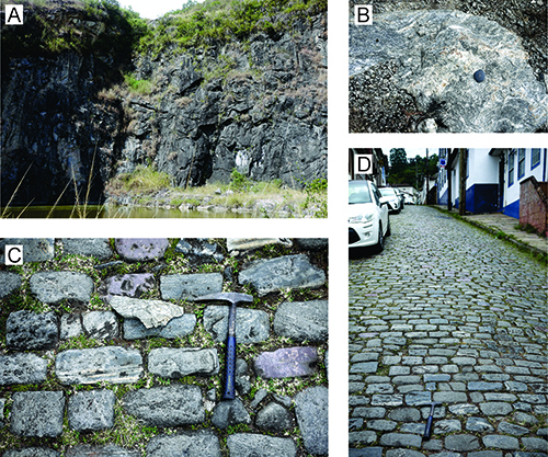 Formaciones rocosas naturales y pavimento de piedra en un entorno exterior que incluye un acantilado, una roca con fósil, un muro de piedra con un martillo geológico y una calle empedrada con vehículos estacionados.

Descripción generada con IA
